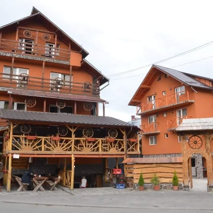 Vila Ardealul — clădiri portocalii cu roți de lemn